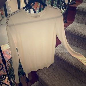 Cream top with circle cut outs along sleeves